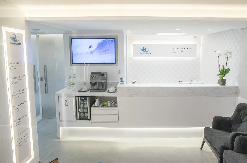 Recepção da RC Odontologia com o logo RC na parede, máquina de café, design clean